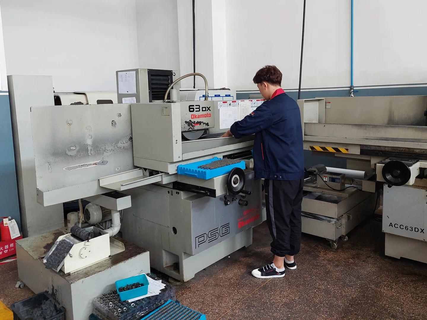 Operator working at an OKAMOTO surface grinding machine
